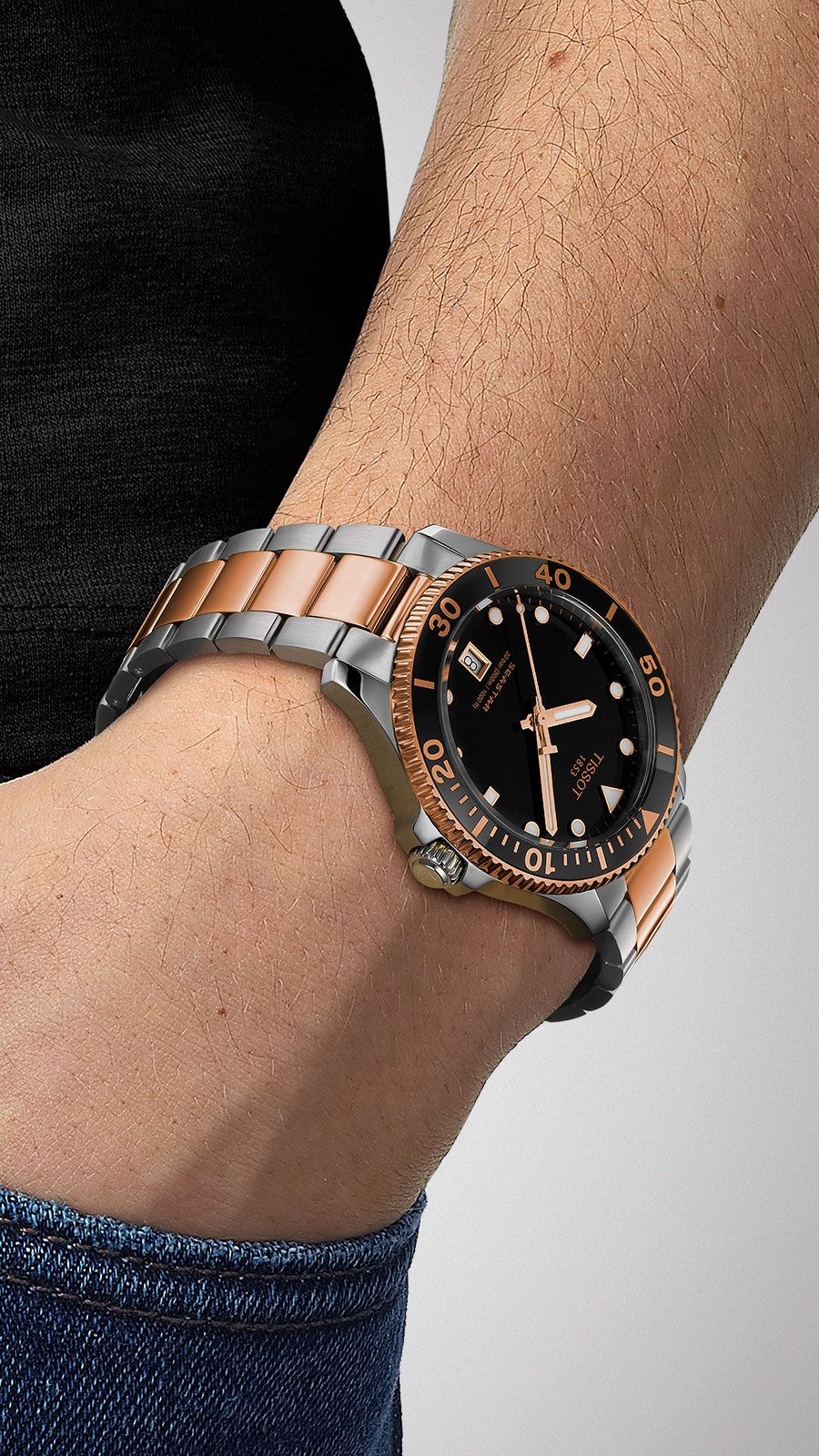 Tissot Seastar 1000 watch on wrist showing case and two-tone bracelet with black dial