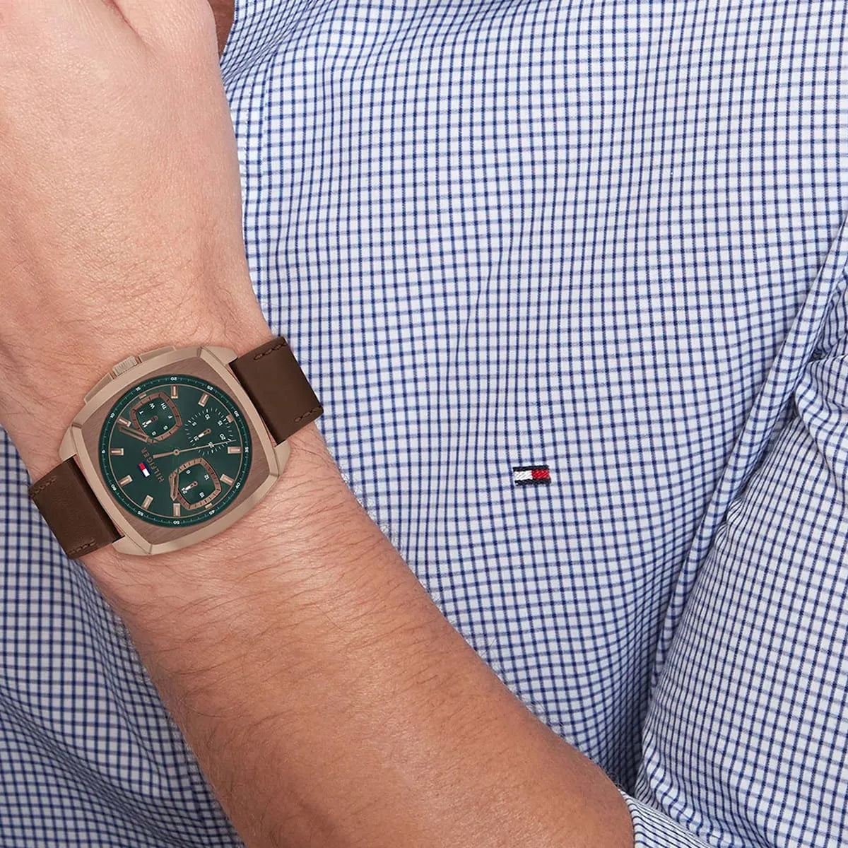 Tommy Hilfiger watch worn on wrist with green dial and brown leather strap