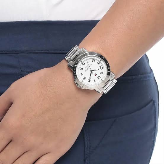 Tommy Hilfiger watch worn on wrist, displaying white dial and silver steel bracelet