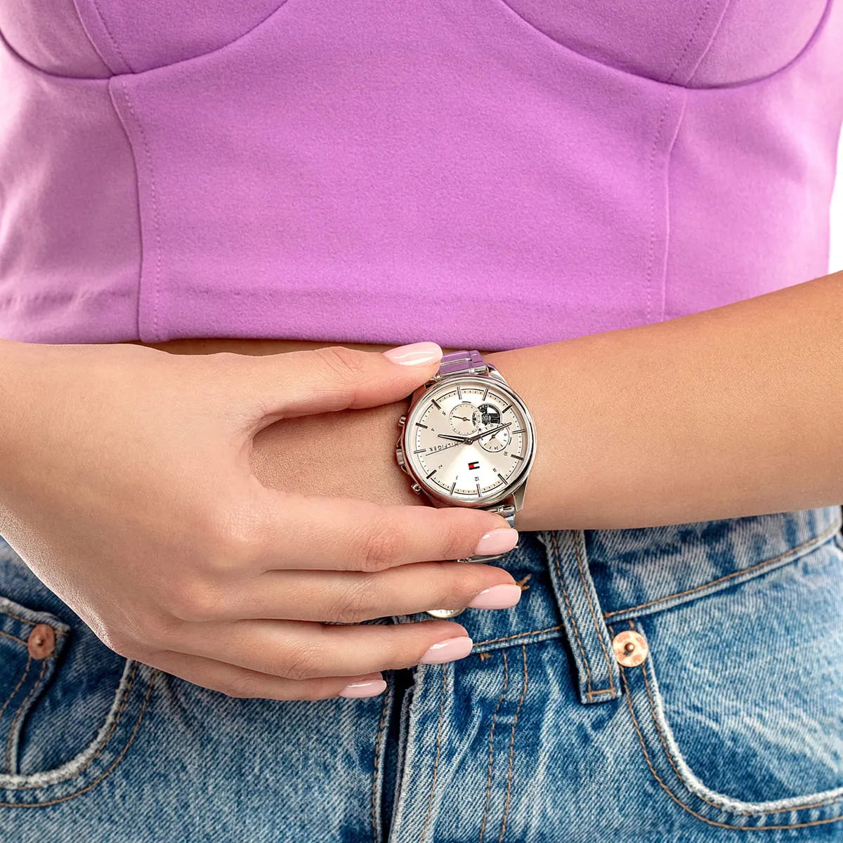 Tommy Hilfiger watch with pink dial worn on wrist with pink sleeve