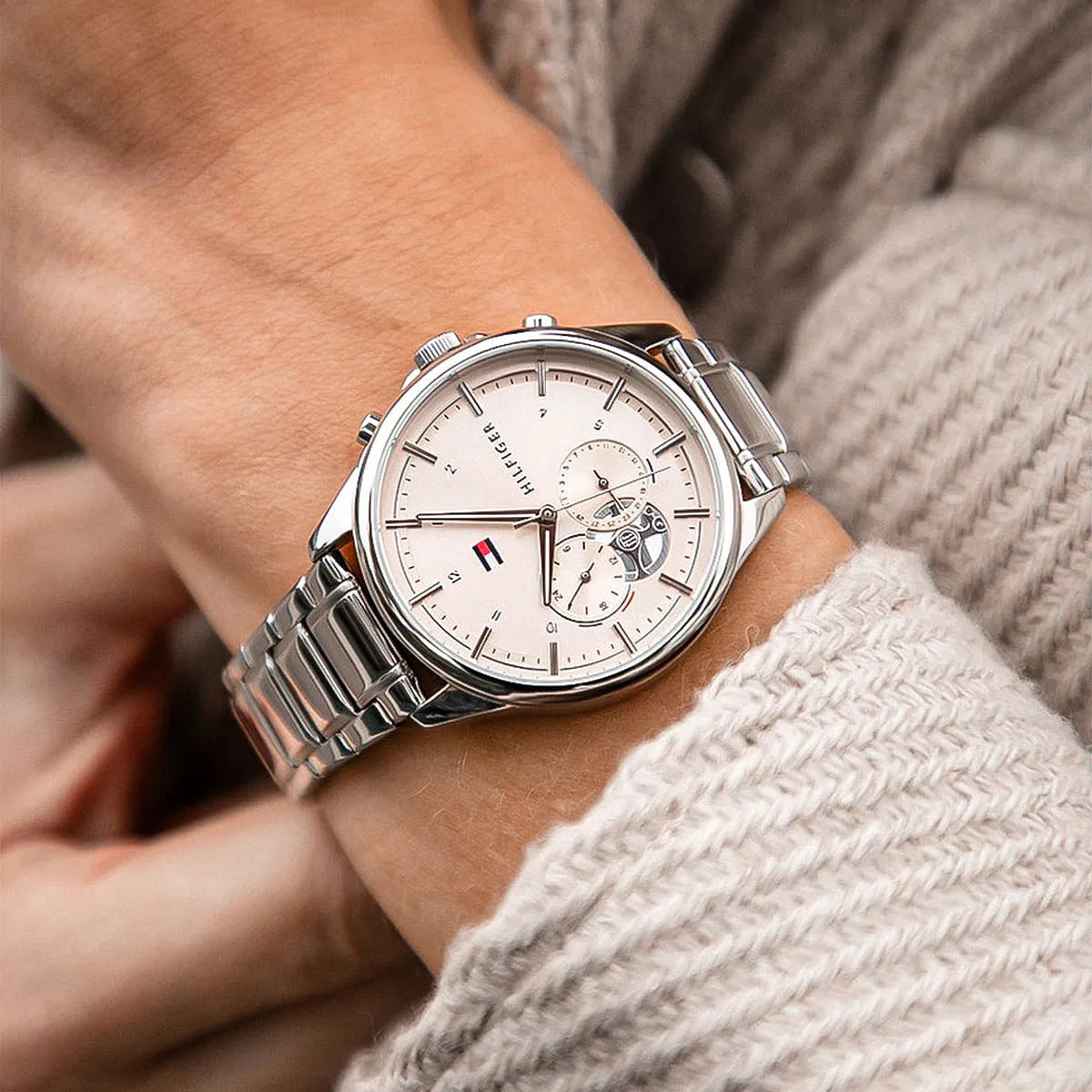 Tommy Hilfiger multifunction watch worn on wrist showing white dial and silver bracelet