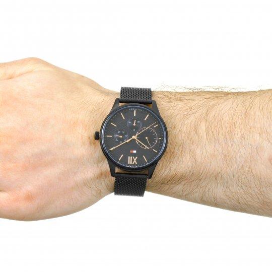 All-black Tommy Hilfiger chronograph watch worn on male wrist