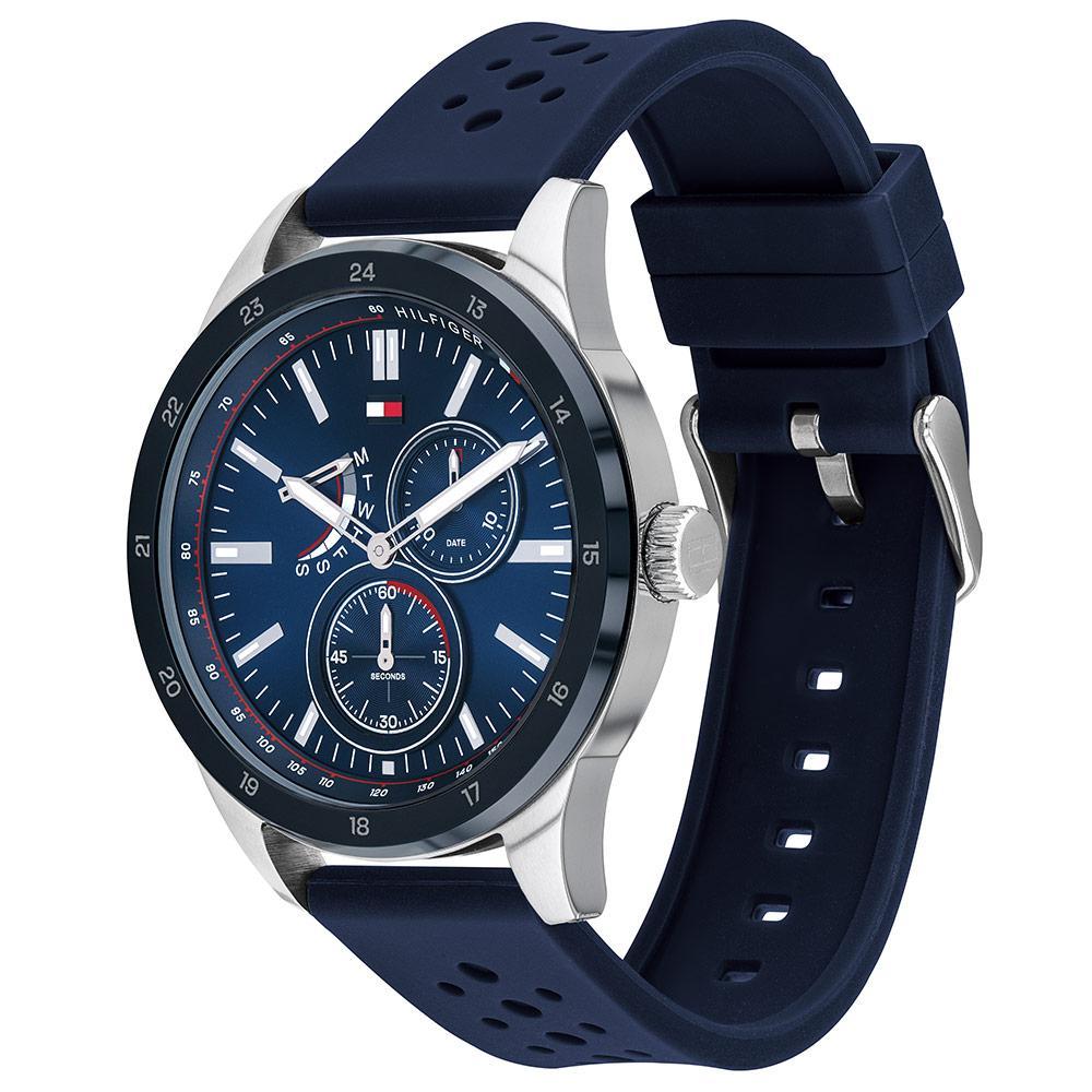 Tommy Hilfiger watch shown at angle displaying silver case and blue silicone strap with perforations