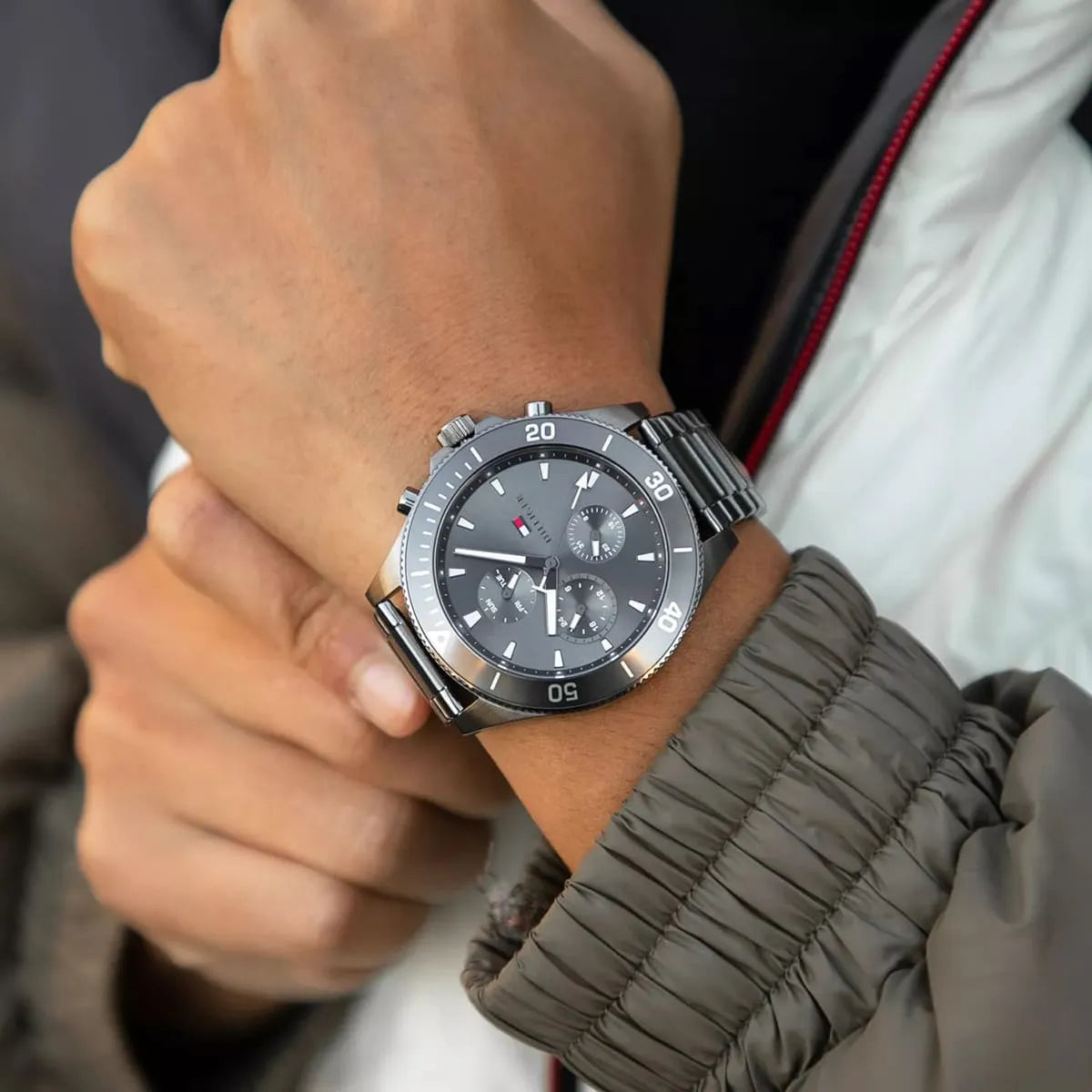 Tommy Hilfiger chronograph watch worn on wrist with dark gray dial and steel bracelet