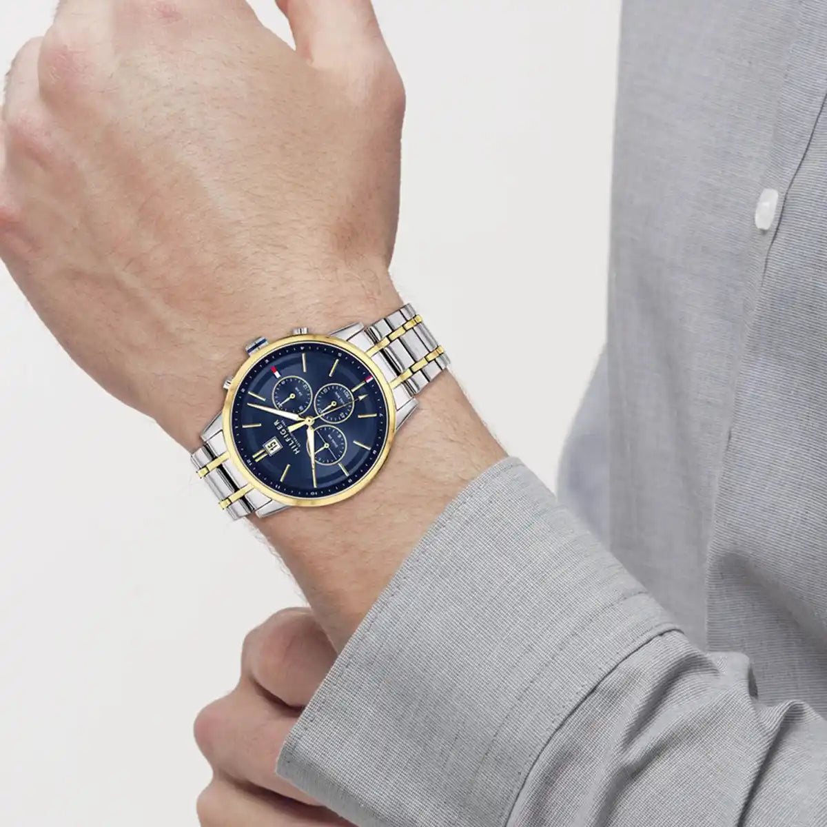 Tommy Hilfiger 1791981 chronograph watch on wrist showing navy dial and two-tone metal bracelet
