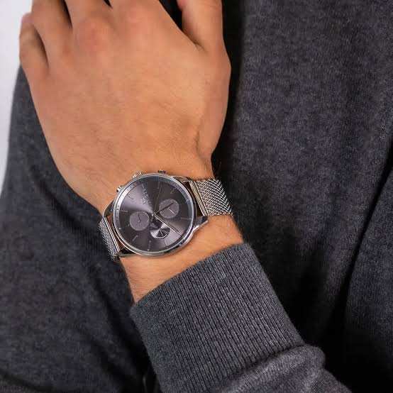 Tommy Hilfiger Chase grey dial watch worn on wrist with silver mesh bracelet