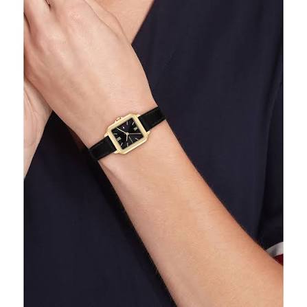 Tommy Hilfiger Mia watch worn on wrist with black leather strap and gold-tone square case