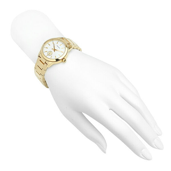 Tory Burch Collins yellow gold watch on mannequin hand showing white dial and bracelet