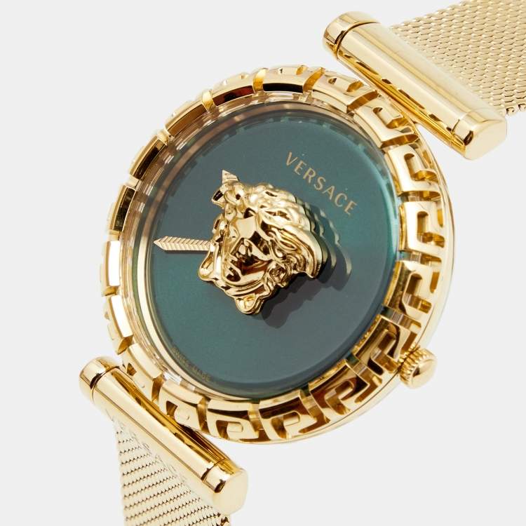 Close-up of green dial with Medusa logo and Greca pattern bezel on gold case