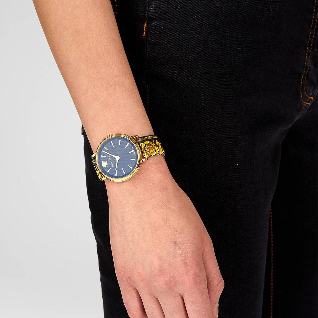 Versace V-Circle watch worn on wrist showing black dial and ornamental gold leather strap