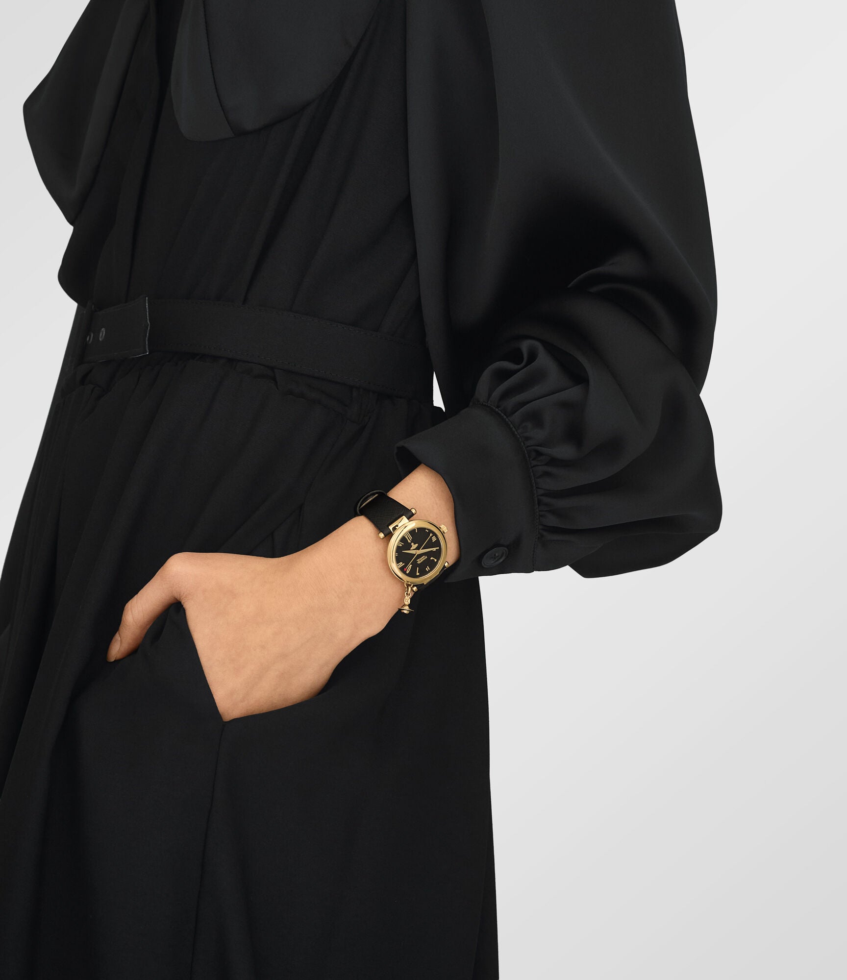 Vivienne Westwood Orb watch on wrist with gold case and black leather strap