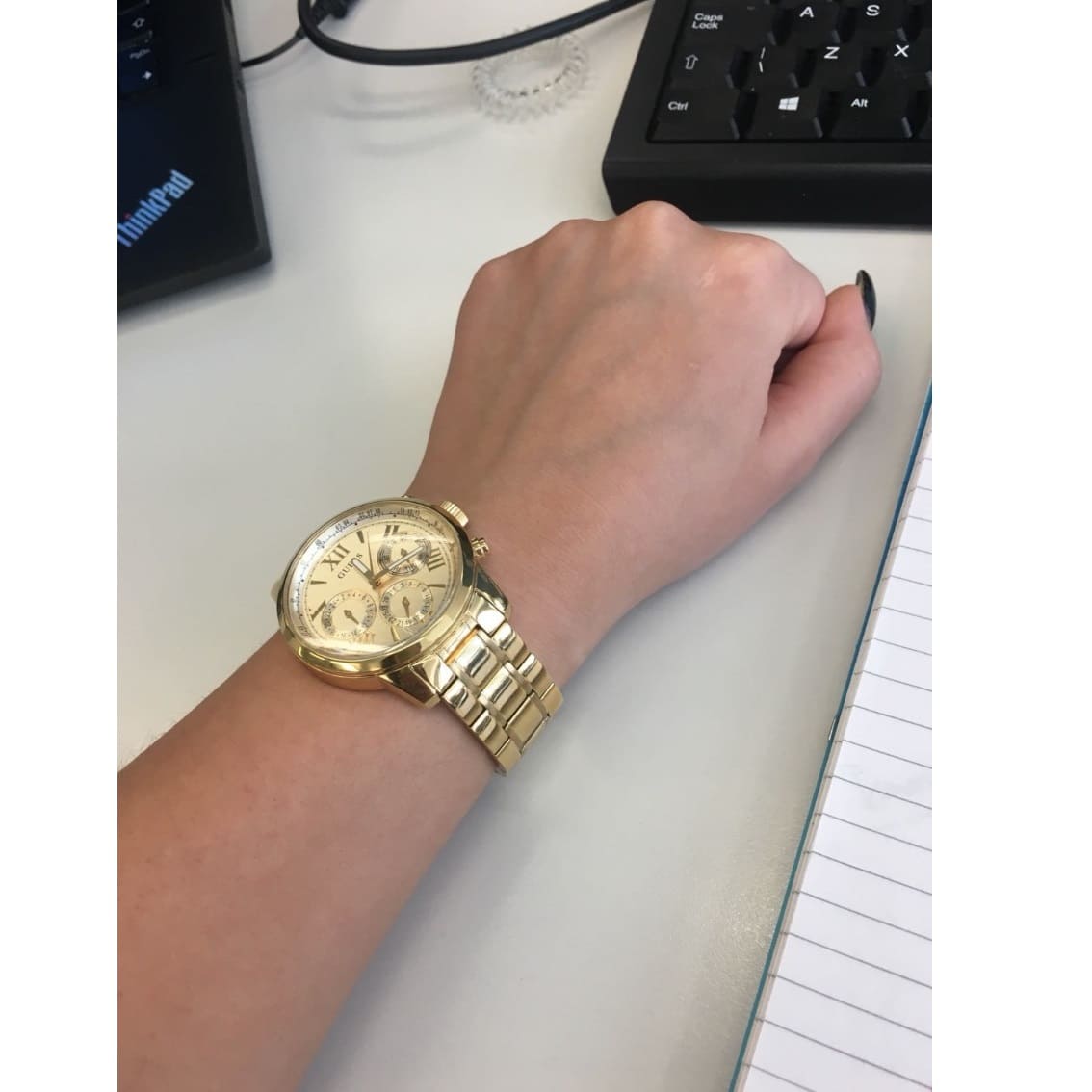 Guess Sunrise gold chronograph watch with multifunction dial on wrist, side view