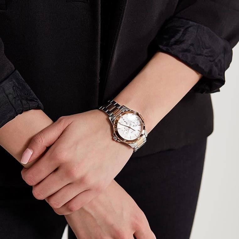 Guess Mist watch worn on wrist with two-tone bracelet and silver dial visible