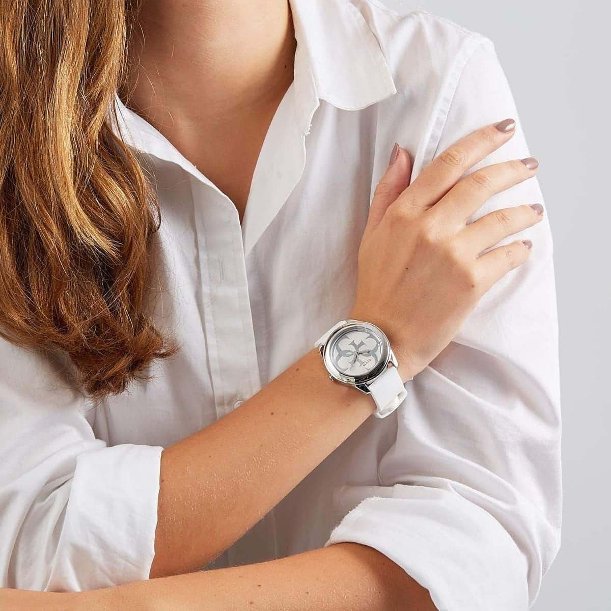 Woman wearing Guess G Twist watch with white strap and silver case